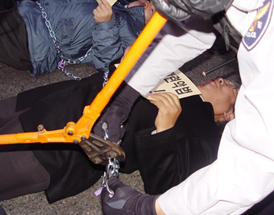 바닥에 누운 목회자의 쇠사슬 끊어내는 경찰